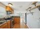Functional kitchen space with a sink, appliances, and hardwood floors connecting seamlessly to living area at 7511 N Ola Ave, Tampa, FL 33604