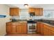 A kitchen with a stainless steel range and microwave, wooden cabinets, stone backsplash and laminate flooring at 7511 N Ola Ave, Tampa, FL 33604