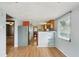Modern kitchen featuring stainless steel refrigerator and hardwood flooring, leading to the living room at 7511 N Ola Ave, Tampa, FL 33604