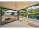 Covered patio with string lights, leading to a driveway with a carport, and a cozy fire pit area at 7511 N Ola Ave, Tampa, FL 33604