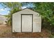 Exterior view of a backyard shed with a simple design and surrounded by foliage at 7511 N Ola Ave, Tampa, FL 33604