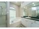 Bathroom featuring a soaking tub, glass block window and a glass enclosed shower at 10219 Millport Dr, Tampa, FL 33626
