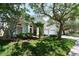 Inviting home with a manicured front yard, lush landscaping, and mature trees at 10219 Millport Dr, Tampa, FL 33626