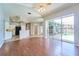 Open-concept living room boasts hardwood floors, view of modern kitchen, and sliding glass doors to screened pool at 10219 Millport Dr, Tampa, FL 33626