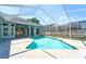 Sparkling pool surrounded by screened enclosure, with view of the home's exterior at 10219 Millport Dr, Tampa, FL 33626