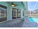 Covered outdoor pool with stone tile and ceiling fans, accessible through glass sliding doors at 10219 Millport Dr, Tampa, FL 33626