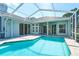 Private pool surrounded by screened enclosure and view of home's covered patio at 10219 Millport Dr, Tampa, FL 33626