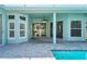 Poolside view of home exterior, showcasing screened windows and covered porch at 10219 Millport Dr, Tampa, FL 33626