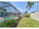 Backyard featuring a screened-in pool area with a green lawn at 10219 Millport Dr, Tampa, FL 33626