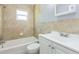 Bright bathroom features a tub with shower, toilet, vanity, and tiled walls at 106 Avery Ave, Crystal Beach, FL 34681