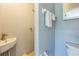 Powder room with a pedestal sink, toilet, and towel rack on a blue accent wall at 106 Avery Ave, Crystal Beach, FL 34681