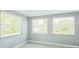 Bright bedroom with three large windows and wood-look flooring at 106 Avery Ave, Crystal Beach, FL 34681