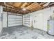 Unfinished garage with built-in shelving, water heater, and a garage door at 106 Avery Ave, Crystal Beach, FL 34681