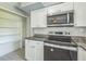 Close-up of the kitchen area showcases stainless steel appliances, granite countertops, and white cabinets at 106 Avery Ave, Crystal Beach, FL 34681