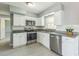Modern kitchen with stainless steel appliances, granite countertops, white cabinetry, and gray walls at 106 Avery Ave, Crystal Beach, FL 34681