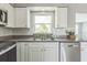 Well-lit kitchen features stainless steel appliances, granite countertops, and white cabinetry at 106 Avery Ave, Crystal Beach, FL 34681
