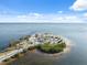Scenic aerial view of a sandy beach, palm trees, and tropical waterway under sunny skies at 108 Shore Dr, Tarpon Springs, FL 34689