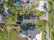 Aerial view showing home's placement among lush greenery, other houses, and a pool at 108 Shore Dr, Tarpon Springs, FL 34689