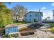 Backyard with an overgrown swimming pool and trees behind the blue house at 108 Shore Dr, Tarpon Springs, FL 34689