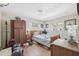 Bedroom with a wooden bed frame, small desk, and cluttered with various personal items at 108 Shore Dr, Tarpon Springs, FL 34689