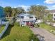 Charming home with a cozy front porch, well-kept lawn, and ample parking in the paved driveway at 108 Shore Dr, Tarpon Springs, FL 34689