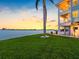 Beautifully landscaped backyard with waterfront views, lush grass, and mature palm trees at 11000 8Th E St, Treasure Island, FL 33706