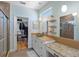 Bright bathroom with a glass bowl sink, vanity, and walk-in closet filled with clothes and other organizational items at 11000 8Th E St, Treasure Island, FL 33706