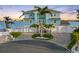 Beautifully landscaped coastal home featuring a three-car garage, well-manicured lawn, and scenic waterfront views at 11000 8Th E St, Treasure Island, FL 33706