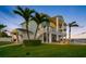 Stylish waterfront home with multiple balconies, an outdoor lounge area, and lush green landscaping at 11000 8Th E St, Treasure Island, FL 33706