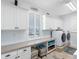 Functional laundry room with large countertops, storage cabinets, a window, and updated appliances at 11000 8Th E St, Treasure Island, FL 33706