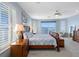 Bright main bedroom featuring water views, plantation shutters, and a luxurious wooden sleigh bed at 11000 8Th E St, Treasure Island, FL 33706