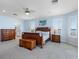 Well-lit main bedroom showcasing hardwood furniture, neutral carpet, and an ensuite bathroom at 11000 8Th E St, Treasure Island, FL 33706