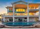 Luxury home featuring a large swimming pool, spacious patio area, and multiple balconies overlooking the water at 11000 8Th E St, Treasure Island, FL 33706