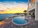 Beautiful pool with stone surround offers tranquil waterfront views and lush backyard landscaping at 11000 8Th E St, Treasure Island, FL 33706