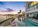 Inviting infinity pool with waterfront views, outdoor seating, and lush landscaping at 11000 8Th E St, Treasure Island, FL 33706