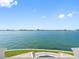 Open water view showcasing a waterfront property with a manicured lawn and cityscape backdrop at 11000 8Th E St, Treasure Island, FL 33706