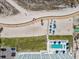 Breathtaking aerial view showcasing beach access, inviting pool, and nearby parking lot for ultimate convenience at 11500 Gulf Blvd # 513, Treasure Island, FL 33706