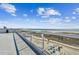 Expansive balcony view overlooking the beach and ocean with clear glass railings, inviting relaxation and scenic vistas at 11500 Gulf Blvd # 513, Treasure Island, FL 33706