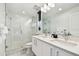Modern bathroom featuring a glass-enclosed shower, double sinks, and bright lighting fixtures at 11500 Gulf Blvd # 513, Treasure Island, FL 33706