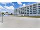 Serene beach scene with volleyball net, lounge chairs, and the building, providing a vacation-like atmosphere at 11500 Gulf Blvd # 513, Treasure Island, FL 33706