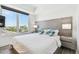 A bedroom featuring a gray headboard, large window with city views, and two side tables with lamps at 11500 Gulf Blvd # 513, Treasure Island, FL 33706