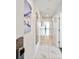 Long, bright hallway with white walls, marble floors, and artwork, leading to the unit's entrance at 11500 Gulf Blvd # 513, Treasure Island, FL 33706