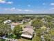 This aerial view highlights the property's neighborhood and mature trees, and also shows the screened-in porch at 11974 Rosetree S Pl, Seminole, FL 33772