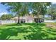 Expansive backyard, enclosed by a white fence, with mature trees providing shade at 11974 Rosetree S Pl, Seminole, FL 33772