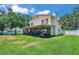 Lush green backyard with a screened patio, bordered by mature trees at 11974 Rosetree S Pl, Seminole, FL 33772