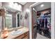 Bathroom vanity with an adjacent door to a walk-in closet at 11974 Rosetree S Pl, Seminole, FL 33772