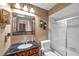 Bathroom featuring a shower, commode, and vanity with an elegant mirror at 11974 Rosetree S Pl, Seminole, FL 33772
