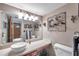 Bathroom featuring a decorative mirror, vessel sink, custom vanity, and decorative wall sculptures at 11974 Rosetree S Pl, Seminole, FL 33772