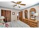 Bedroom features a ceiling fan, closet, dresser, and mirrors at 11974 Rosetree S Pl, Seminole, FL 33772