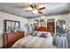 Bedroom features a wooden dresser, mirrors, and ceiling fan at 11974 Rosetree S Pl, Seminole, FL 33772